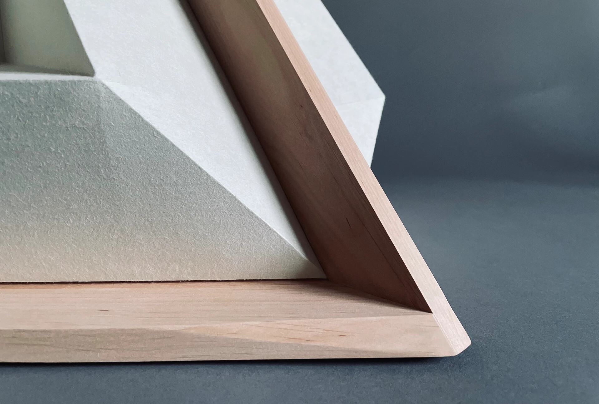 Close detail of the alder wood edge meeting the recycled textile surface